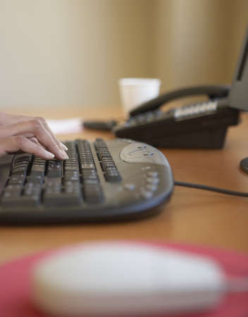 Close-up of a young woman's hand using a computerの写真素材