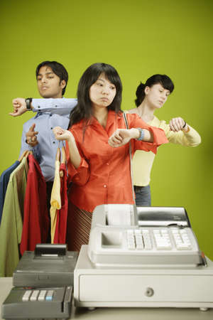 Two young women and a young man waiting in line at a checkout counter