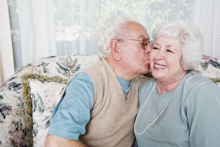Senior man kissing senior woman on cheekの写真素材