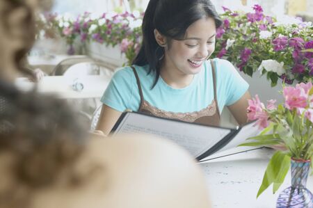 Young woman smiling reading a bookの写真素材