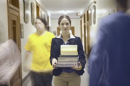 Teenage girl carrying booksの写真素材