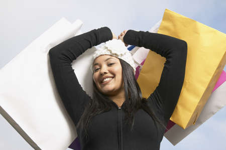 Low angle view of a young woman holding shopping bags