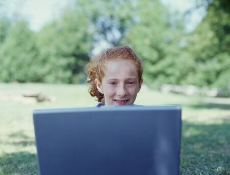 Girl in park with laptopの写真素材