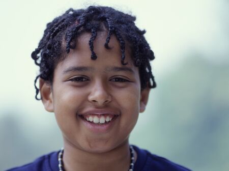 Close up portrait of boy with dred locks smilingの写真素材