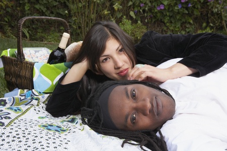 Portrait of couple laying on blanket with picnic basketの写真素材