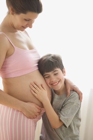 Son hugging pregnant motherÃ­s bellyの写真素材