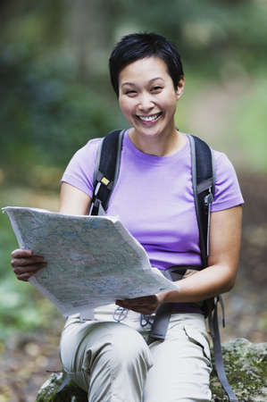 Woman wearing backpack reading map