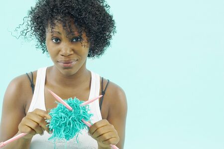 Portrait of woman with tangled yarn and knitting needlesの写真素材