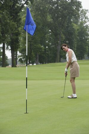 Woman playing golfの写真素材
