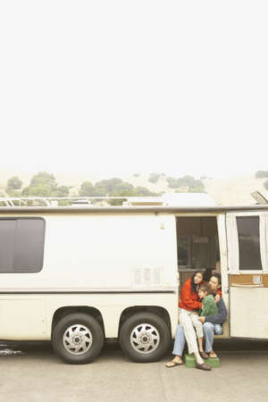 Mother and son sitting in doorway to recreational vehicleの写真素材