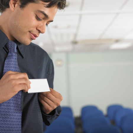 Businessman attaching name tag to jacketの写真素材