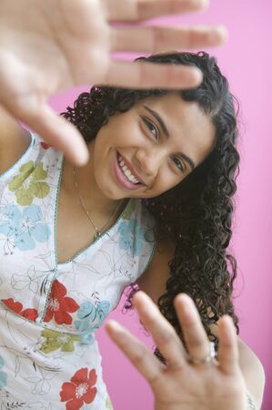 Portrait of teenage girl smiling with hands raisedの写真素材