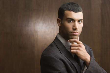 Portrait of businessman holding chin with handの写真素材