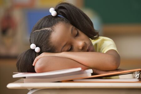 Student sleeping at her deskの写真素材