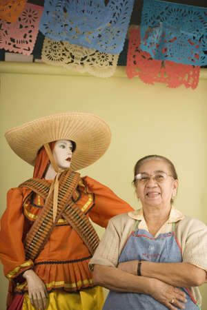 Senior woman standing beside mannequin