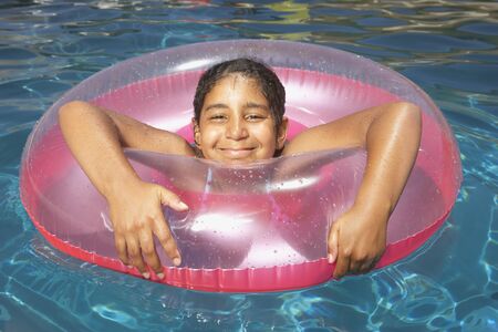 Young girl floating in an inner tube