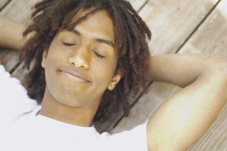 Teenage boy asleep on woodの写真素材