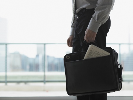 Young businessman holding his briefcaseの写真素材