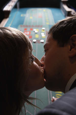 Couple kissing at a gambling table