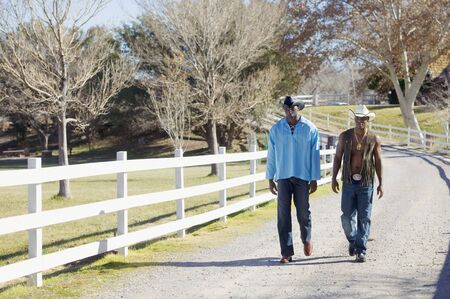 Young men walking on rural roadの写真素材