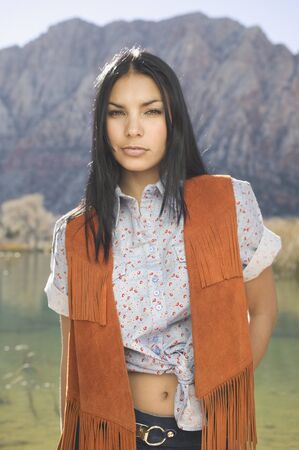 Young woman in cowboy outfit posing for the camera