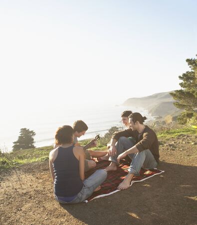 Friends having a picnic on dirt pathの写真素材