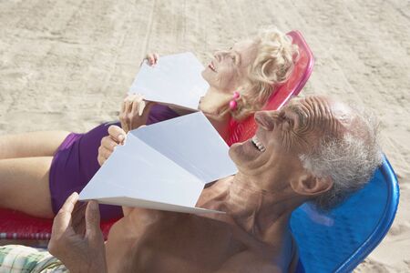 Senior couple sunning themselves at the beachの写真素材