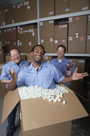 Three male warehouse workers joking around