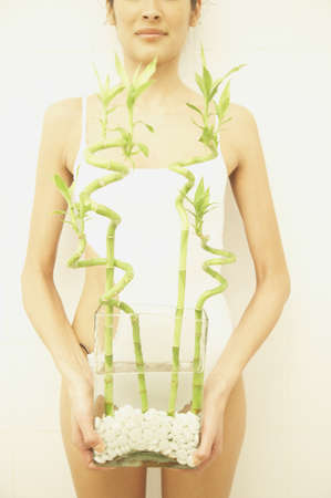 Woman holding vase with bambooの写真素材