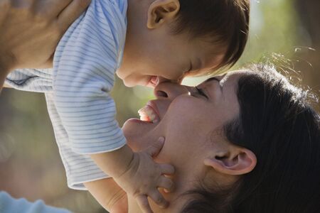 Close up of Hispanic mother and baby touching nosesの写真素材