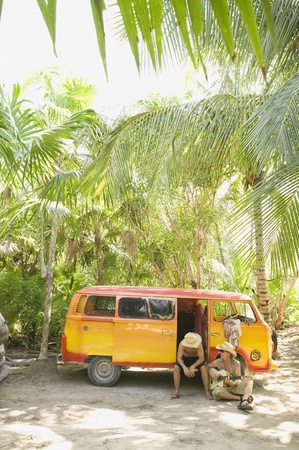 People sitting with van in tropical settingの写真素材