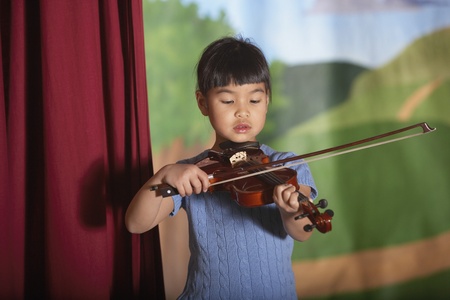 Young Asian girl playing violin at recitalの写真素材