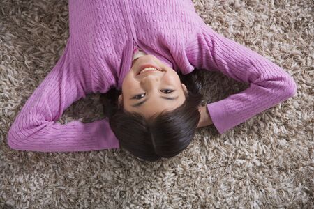 Young Hispanic girl lying on floorの写真素材