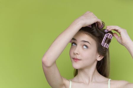 Studio shot of young girl with curlers の写真素材