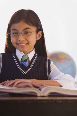 Young Hispanic girl at desk in classroom の写真素材