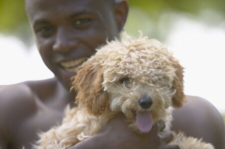 African man holding small dogの写真素材