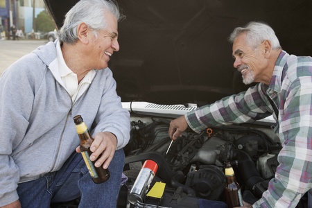 Two senior men working under hood of carの写真素材