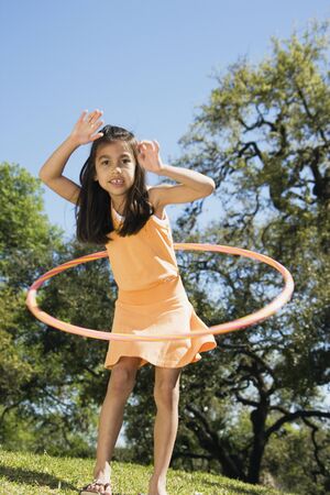 Hispanic girl playing with hula hoop outdoorsの写真素材