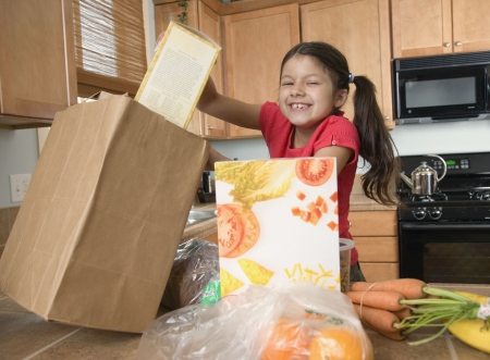 Hispanic girl unpacking groceries in kitchenの写真素材