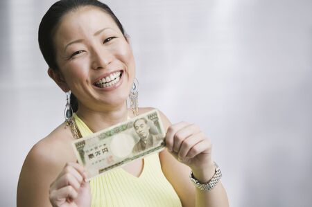 Close up of Asian woman holding moneyの写真素材