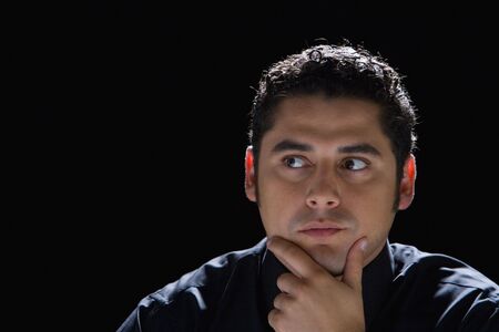 Hispanic man with hand on chinの写真素材