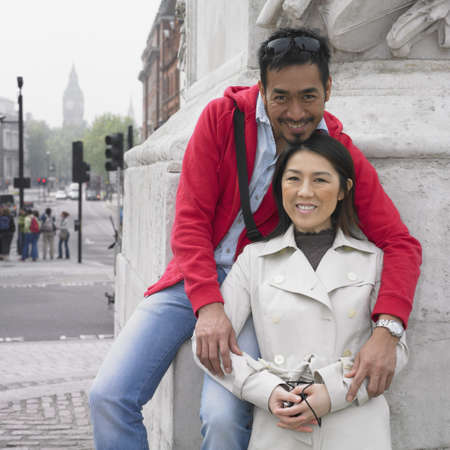 Asian couple hugging and smiling in Londonの写真素材