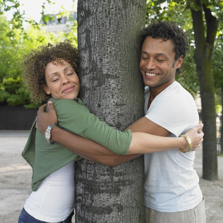 Couple smiling and hugging treeの写真素材