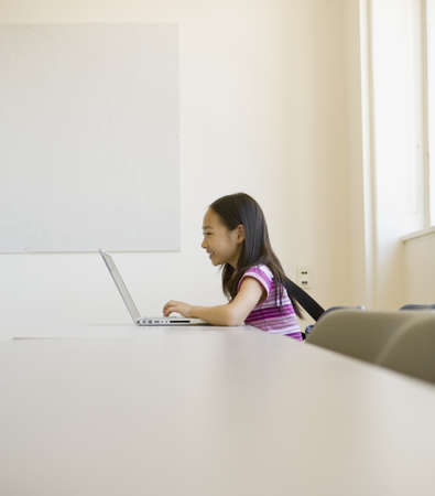 Asian girl using laptop and smiling