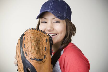 Hispanic woman smiling with baseball gloveの写真素材