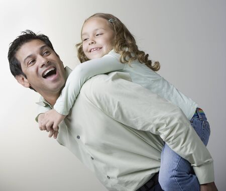 Hispanic father giving daughter piggyback rideの写真素材