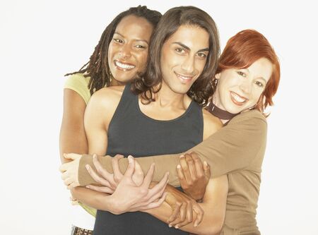 Studio shot of man being hugged by two womenの写真素材