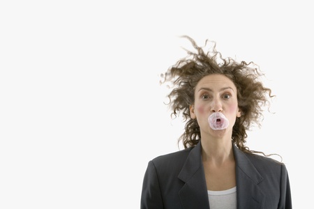 Hispanic businesswoman with popped bubblegum on faceの写真素材