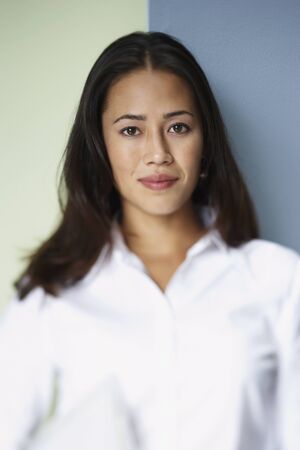 Portrait of Asian woman leaning against wallの写真素材