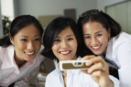 Asian businesswomen taking own photographの写真素材